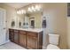 Bathroom featuring double sinks, a large mirror, and modern fixtures, with neutral tones and ample lighting at 5392 Sanctuary Ave, Firestone, CO 80504