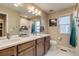 Bathroom with a double sink vanity, a large mirror, and natural light from the window at 5392 Sanctuary Ave, Firestone, CO 80504