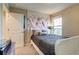 Bedroom showcasing neutral decor with a comfortable bed, accent wall hanging, and a bright window view at 5392 Sanctuary Ave, Firestone, CO 80504