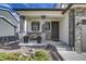 Inviting covered porch with stone pillars, seating, and stylish planters at 5392 Sanctuary Ave, Firestone, CO 80504