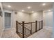 Upstairs hallway with a modern metal railing and neutral carpeting at 5392 Sanctuary Ave, Firestone, CO 80504