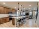 Open-concept kitchen featuring a large island with seating, stainless appliances, and hardwood floors at 5392 Sanctuary Ave, Firestone, CO 80504