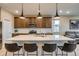 Close-up of a kitchen island with pendant lighting, seating, and stainless steel appliances at 5392 Sanctuary Ave, Firestone, CO 80504