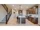 Modern kitchen features stainless appliances, island with seating, and hardwood floors at 5392 Sanctuary Ave, Firestone, CO 80504