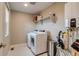 Functional laundry room with a washer, dryer, storage shelf, and essential utilities neatly arranged at 5392 Sanctuary Ave, Firestone, CO 80504