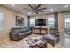 Modern living room with gray leather seating, ceiling fan and wood-look flooring at 5392 Sanctuary Ave, Firestone, CO 80504