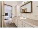 Well-lit bathroom featuring a vanity area with a mirror, and a view to the main bedroom at 664 Stampede Dr, Brighton, CO 80603