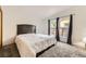 Bright bedroom with neutral carpet, large bed, and two windows offering natural light and neighborhood views at 664 Stampede Dr, Brighton, CO 80603