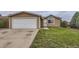 Single-story home with attached garage, complemented by a lush, green front yard at 664 Stampede Dr, Brighton, CO 80603