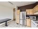 Well-lit kitchen featuring stainless steel appliances, light wood cabinets, and convenient storage at 664 Stampede Dr, Brighton, CO 80603