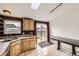Functional kitchen featuring wood cabinets, neutral countertops, tile flooring and access to the backyard at 664 Stampede Dr, Brighton, CO 80603