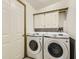 Convenient laundry room equipped with a modern Samsung washer and dryer, plus storage cabinets at 664 Stampede Dr, Brighton, CO 80603