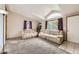 Bright living room with large windows, vaulted ceiling, comfortable seating, and neutral carpet at 664 Stampede Dr, Brighton, CO 80603