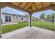Covered patio overlooking the grassy backyard, the home's exterior, and a wood privacy fence at 664 Stampede Dr, Brighton, CO 80603