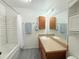 Well-lit bathroom with vanity, storage, and shower with curtain at 2160 Ance St, Strasburg, CO 80136