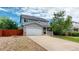 Charming two-story home featuring a well-maintained lawn, a two car garage, and a cozy front porch at 2160 Ance St, Strasburg, CO 80136