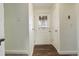 Hallway leading to exterior door, showcasing updated flooring and clean, neutral paint at 9105 Oberon Rd # 2, Arvada, CO 80004