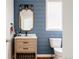 Stylish powder room with blue shiplap walls, modern vanity, decorative mirror, and window at 10069 E 28Th Ave, Denver, CO 80238