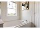 Bright white bathtub next to a window and a doorway at 10069 E 28Th Ave, Denver, CO 80238