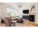 Bright living room featuring a cozy fireplace, large windows, and stylish furnishings for comfortable living at 10069 E 28Th Ave, Denver, CO 80238