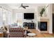 Cozy living room featuring a corner fireplace, large windows, and comfortable seating for relaxing and entertaining at 10069 E 28Th Ave, Denver, CO 80238