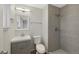 Modern bathroom featuring gray tiled walls, a tiled shower, and a sleek vanity with storage at 19697 E Flora Pl, Aurora, CO 80013