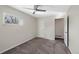 Comfortable carpeted bedroom with a ceiling fan, large window, and attached bathroom door at 19697 E Flora Pl, Aurora, CO 80013