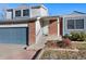 Welcoming entrance to home featuring brick accents, a storm door, and freshly landscaped garden at 19697 E Flora Pl, Aurora, CO 80013