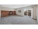 Spacious carpeted living room featuring a brick fireplace and sliding glass doors to the outside at 19697 E Flora Pl, Aurora, CO 80013