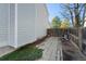 Side yard view with pavers leading to a wooden gate, and lush greenery at 19697 E Flora Pl, Aurora, CO 80013