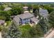 Expansive property featuring a well-maintained lawn, basketball court, covered patio, and lush tree coverage at 2555 S Zang St, Denver, CO 80228