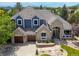 An aerial view of a two story home with a three car garage, well maintained lawn, and mountain views at 2555 S Zang St, Denver, CO 80228