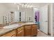 Well-lit bathroom with double sinks, wood cabinets, granite countertops, and a view to another room at 2555 S Zang St, Denver, CO 80228
