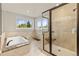 Bright bathroom featuring a soaking tub, step-in shower, and natural light from large windows at 2555 S Zang St, Denver, CO 80228