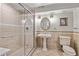 Elegant bathroom features a glass-enclosed shower, pedestal sink, and neutral tile, offering a spa-like retreat at 2555 S Zang St, Denver, CO 80228