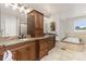 Luxurious bathroom with dual vanities, granite countertops, soaking tub, and glass shower enclosure at 2555 S Zang St, Denver, CO 80228