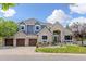 Beautiful two story home featuring a brick and blue exterior, three car garage, and manicured front lawn at 2555 S Zang St, Denver, CO 80228