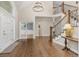 Elegant foyer featuring hardwood floors, a grand staircase with iron spindles, and a modern chandelier at 2555 S Zang St, Denver, CO 80228