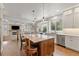 Open kitchen with center island, stainless appliances, and breakfast area with coffered ceiling and fireplace at 2555 S Zang St, Denver, CO 80228
