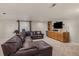 Spacious basement living room featuring a large leather sofa and a bar at 2555 S Zang St, Denver, CO 80228