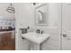 Charming powder room featuring a pedestal sink, modern fixtures, and shiplap accent wall at 2555 S Zang St, Denver, CO 80228