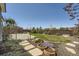 Landscaped backyard with a stone walkway, well-maintained lawn, and mature trees at 21701 E 50Th Dr, Aurora, CO 80019