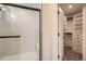 Bright bathroom with white-tiled shower and open closet with shelves at 21701 E 50Th Dr, Aurora, CO 80019
