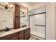 Modern bathroom with double vanity, quartz countertops, and a glass-enclosed shower at 21701 E 50Th Dr, Aurora, CO 80019