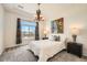 A bright bedroom with a large window, stylish chandelier, and comfy carpet at 21701 E 50Th Dr, Aurora, CO 80019
