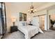 Well-lit bedroom featuring neutral carpet, modern art, and a convenient sliding door leading to the bathroom at 21701 E 50Th Dr, Aurora, CO 80019