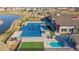 Aerial view of the community pool with a separate shallow area and plenty of seating near a community building at 21701 E 50Th Dr, Aurora, CO 80019