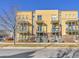 Inviting multi-level townhome with balconies, yellow siding, brick accents, and well-maintained landscaping at 2869 Syracuse Ct, Denver, CO 80238