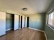 Bedroom with wood floors, a window, and a closet with sliding doors at 8127 Lafayette St, Denver, CO 80229