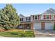 Charming two-story townhome featuring a two-car garage, mature trees, and landscaped front yard at 6459 E Hinsdale Ave, Centennial, CO 80112